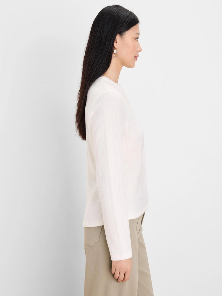 Cream long-sleeve top with subtle cable knit pattern visible throughout the fabric.