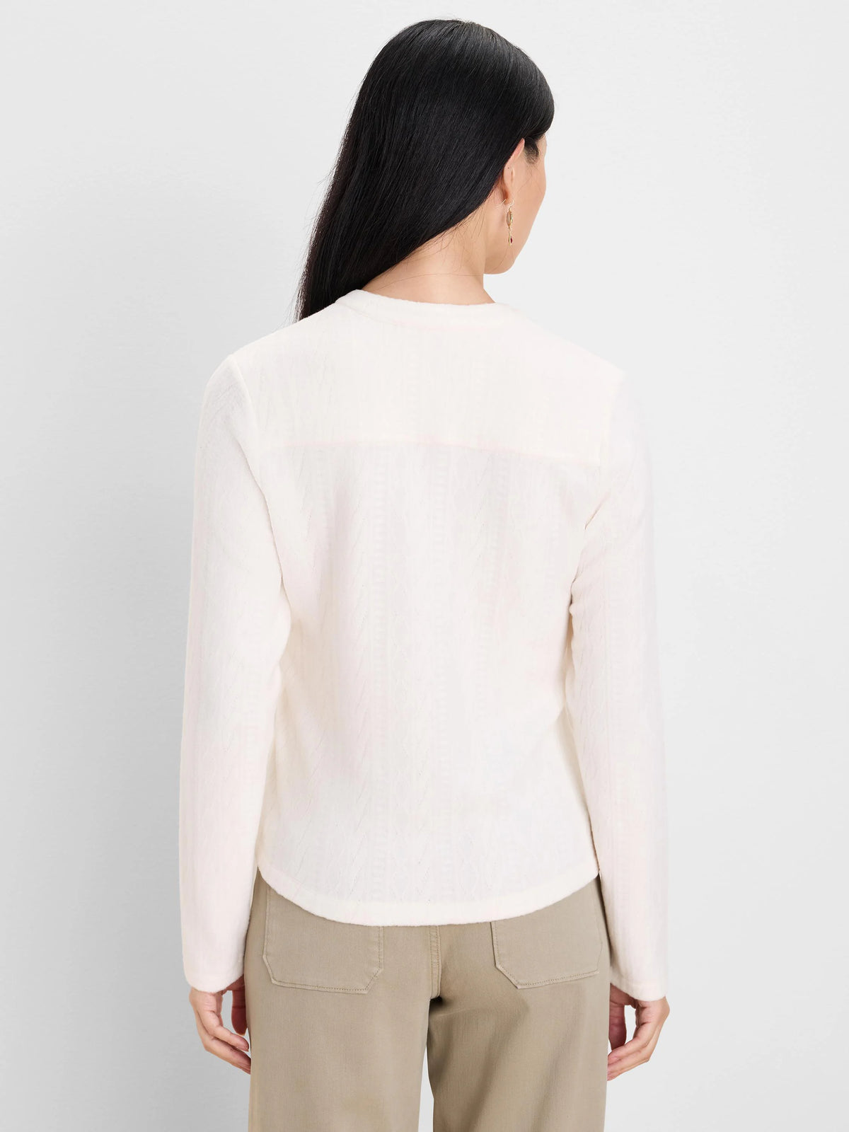 Off-white long-sleeve top with a subtle cable knit pattern, shown on a model from the back.