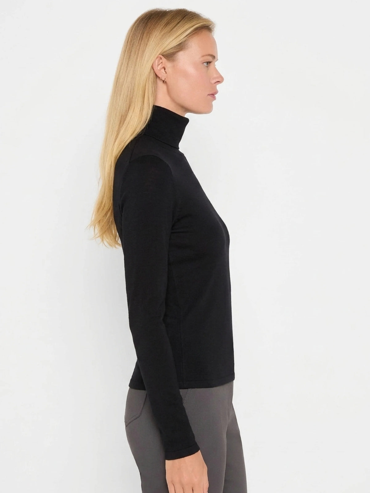 Black rib knit turtleneck with long sleeves, modeled in profile.