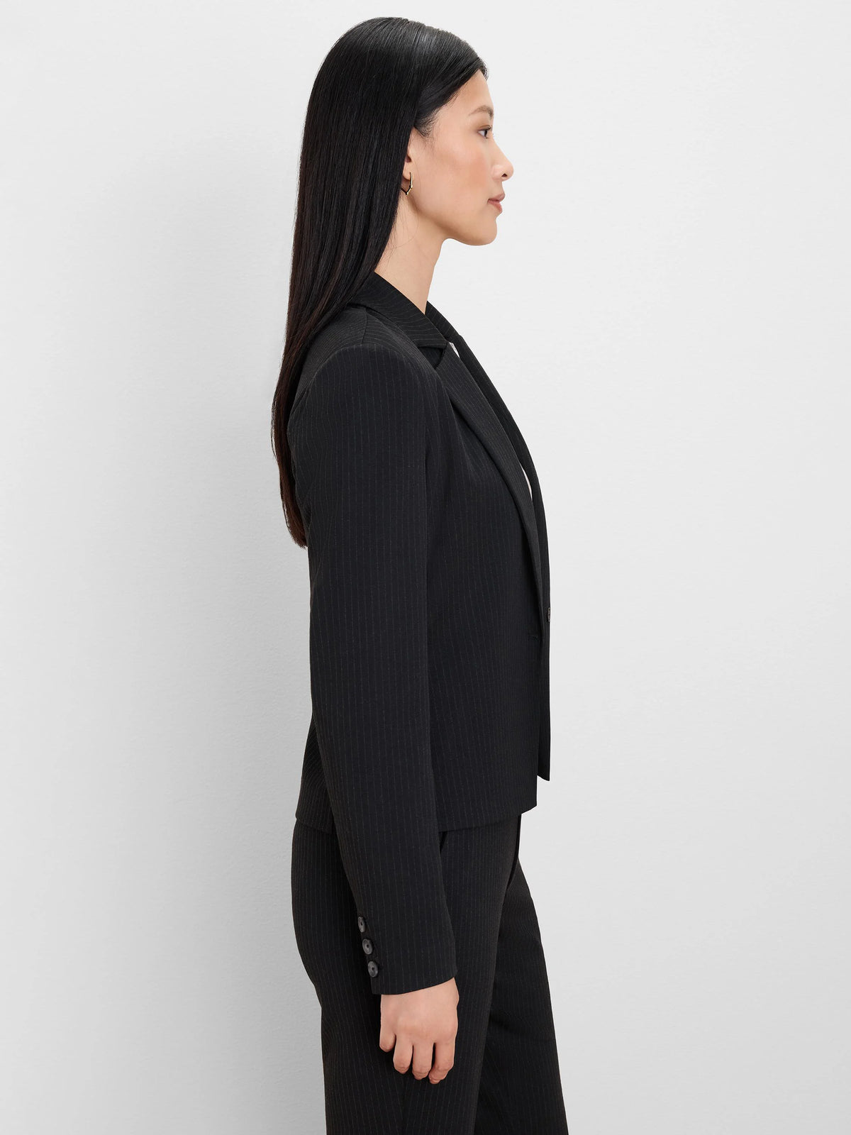 Black pinstripe blazer with notched lapels and three buttons on the sleeve cuffs.