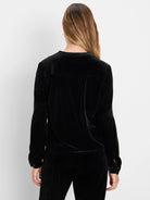 Black velvet long-sleeve top. Features a stand collar, pleated back, and slit cuffs.