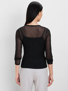 Black sheer mesh top with velvety dots, round neck, 3/4 sleeves, worn over a black camisole.