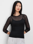 Black sheer long-sleeve top with velveteen dots. Model wears a black camisole underneath.