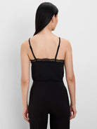Black knit cami, shown from back, with adjustable spaghetti straps and lace trim across the top.