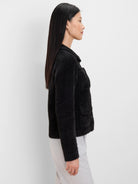 Black fuzzy jacket with patch pockets, dark buttons, and a collar. Side profile view.
