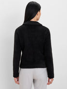 Black fuzzy collared jacket, shown from the back on a model.