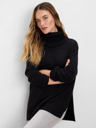Black foldover turtleneck zip sweater with ribbed cuffs, hem, and side slits.
