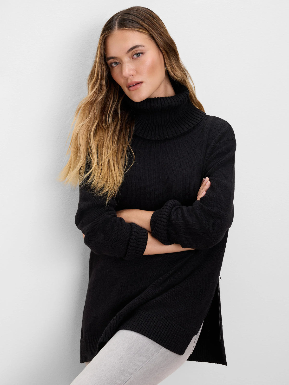 Black foldover turtleneck zip sweater with ribbed cuffs, hem, and side slits.