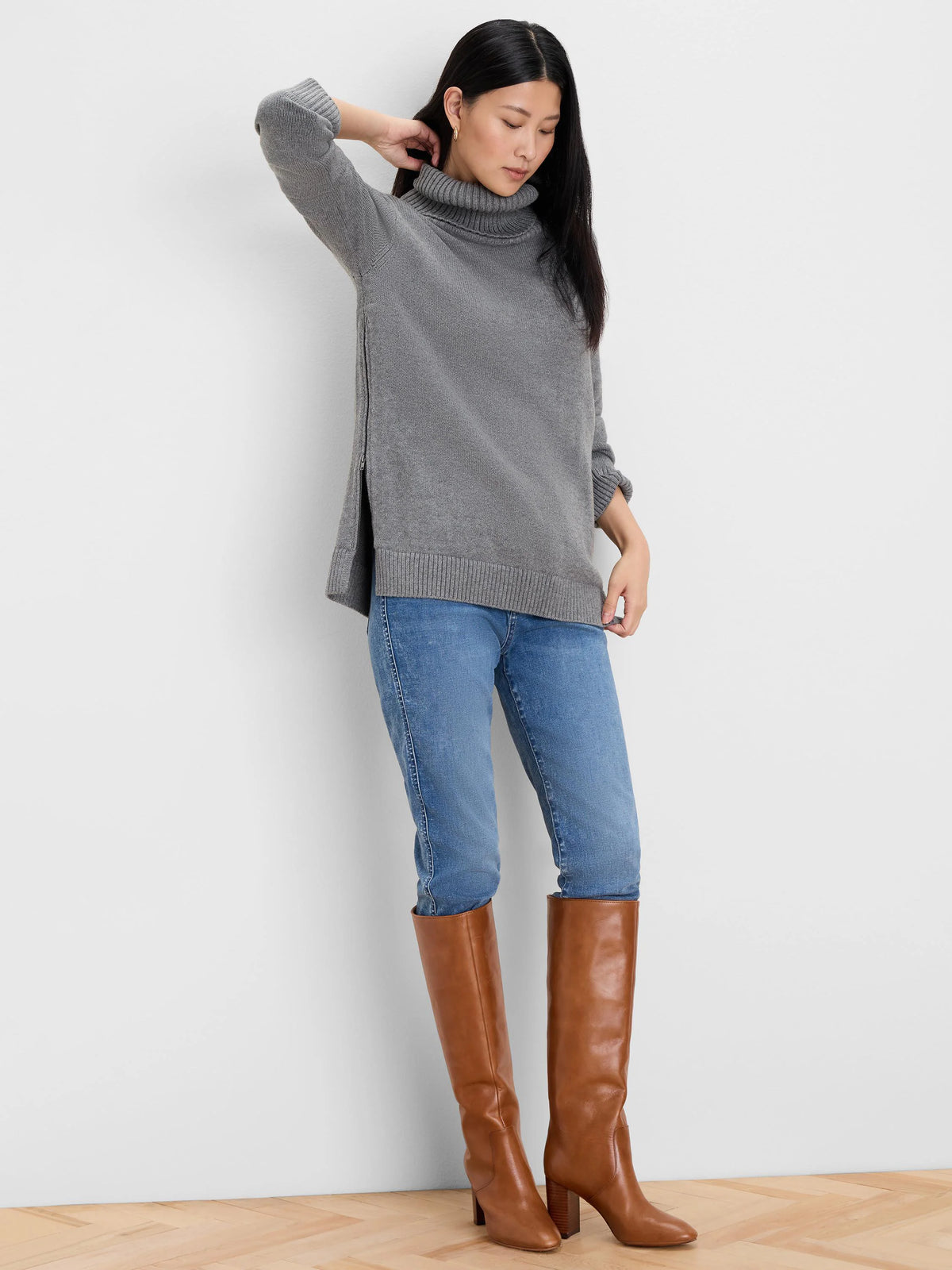 Grey sweater with a ribbed foldover turtleneck and a side zipper creating a slit on the left.