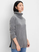 Grey foldover turtleneck sweater with a relaxed fit, ribbed cuffs and hem, and side slits.