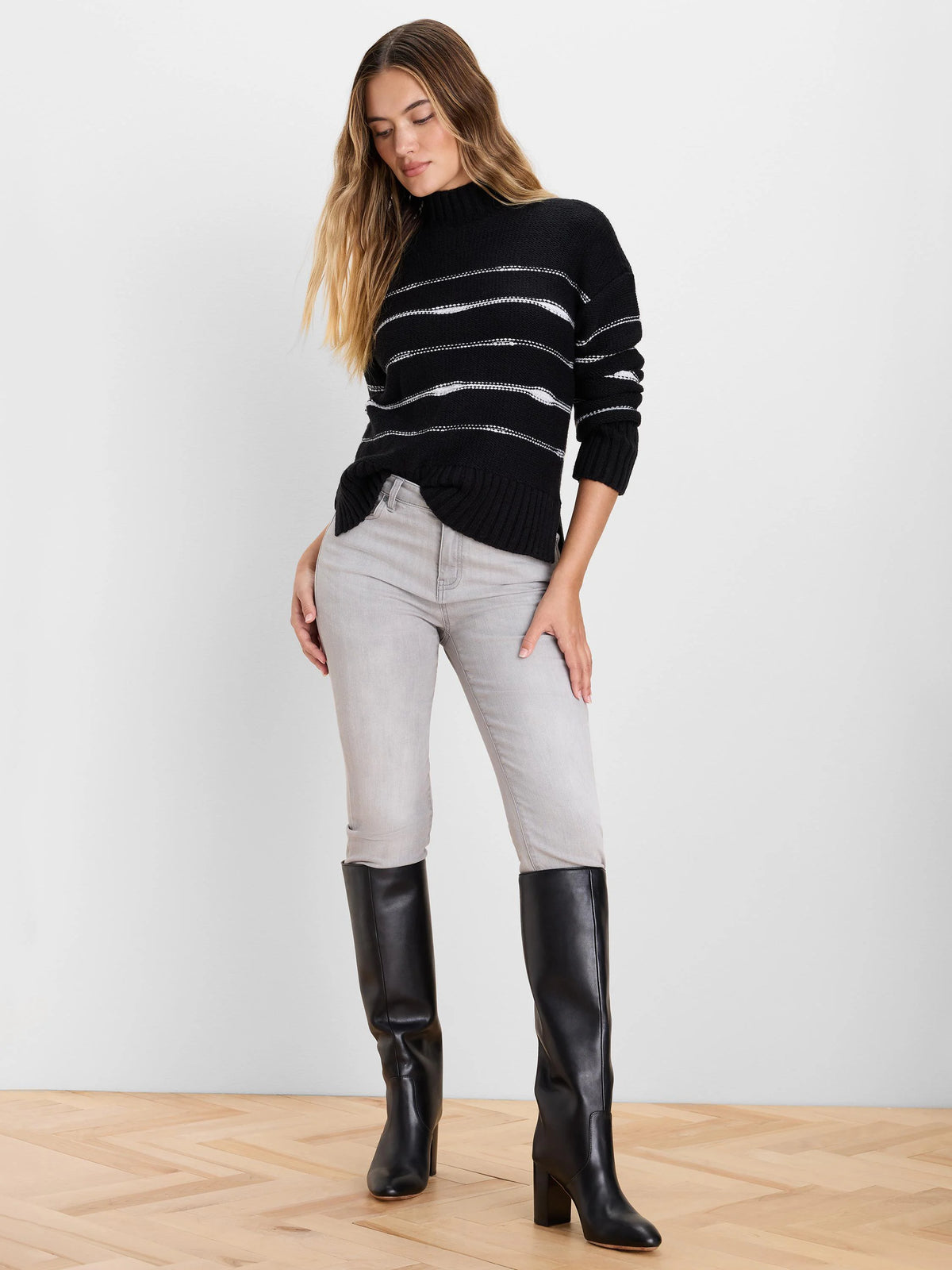 Black mock neck sweater with textured white horizontal stripes, ribbed cuffs and hem.
