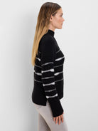 Black mock-neck sweater with textured white horizontal stripes and ribbed cuffs.