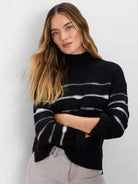 Black mock neck sweater with white dotted horizontal stripes, ribbed cuffs and hem.