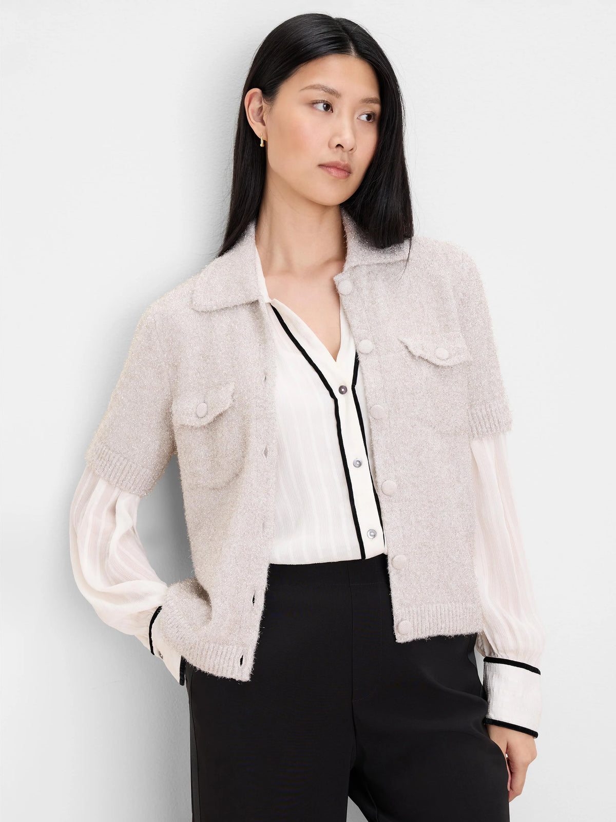Ecru fuzzy knit cardigan with subtle shimmer, short sleeves, button-front, collar, and two buttoned chest pockets.