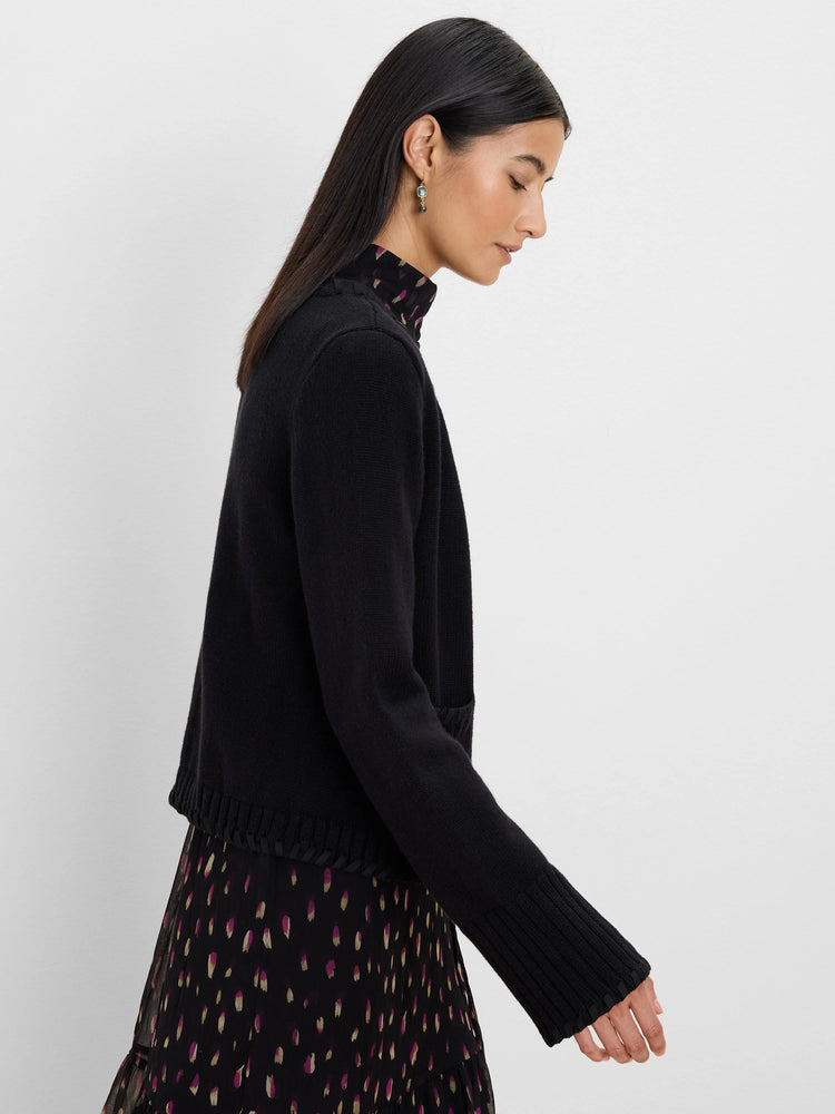 Black knit open cardy jacket with ribbed cuffs, hem, and dark woven trim detail.