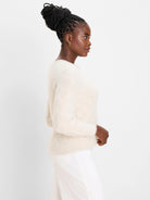Light cream, fuzzy sweater with a subtle diagonal knit pattern and ribbed details.