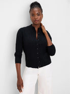 Black mockneck cardigan with cable knit pattern and front buttons.