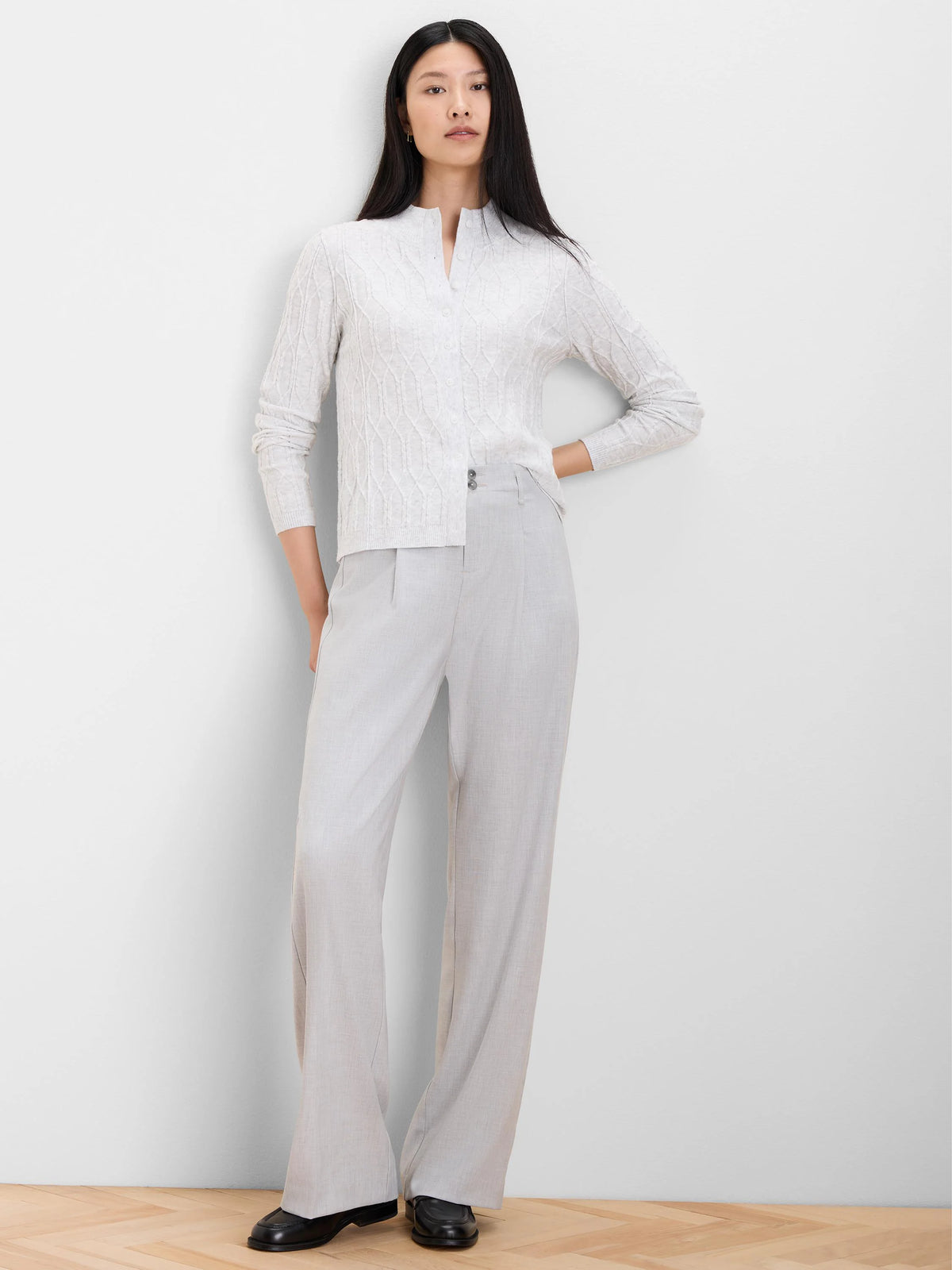 Light gray cable knit cardigan with mockneck collar and front buttons.