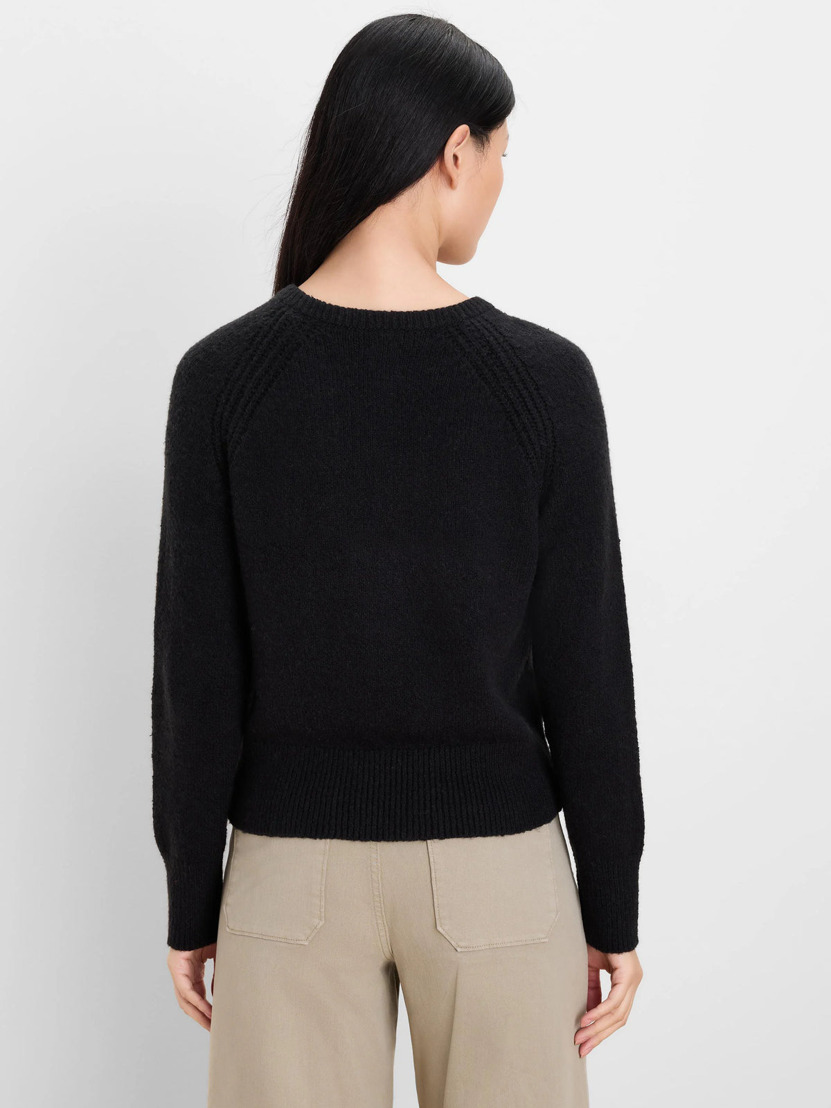 Black, soft-textured sweater with long raglan sleeves, ribbed cuffs & hem. Model shown from behind.