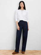 Off-white knit sweater with a round neck, 3-button henley placket, and subtle raglan sleeves.