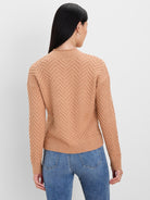 Tan roll neck sweater with a chevron knit pattern on body and sleeves. Ribbed roll neck, cuffs, and hem.