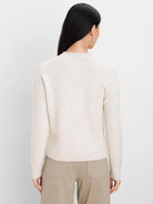 Cream roll neck sweater, back view, with a prominent chevron knit pattern. Ribbed neck, cuffs, and hem.