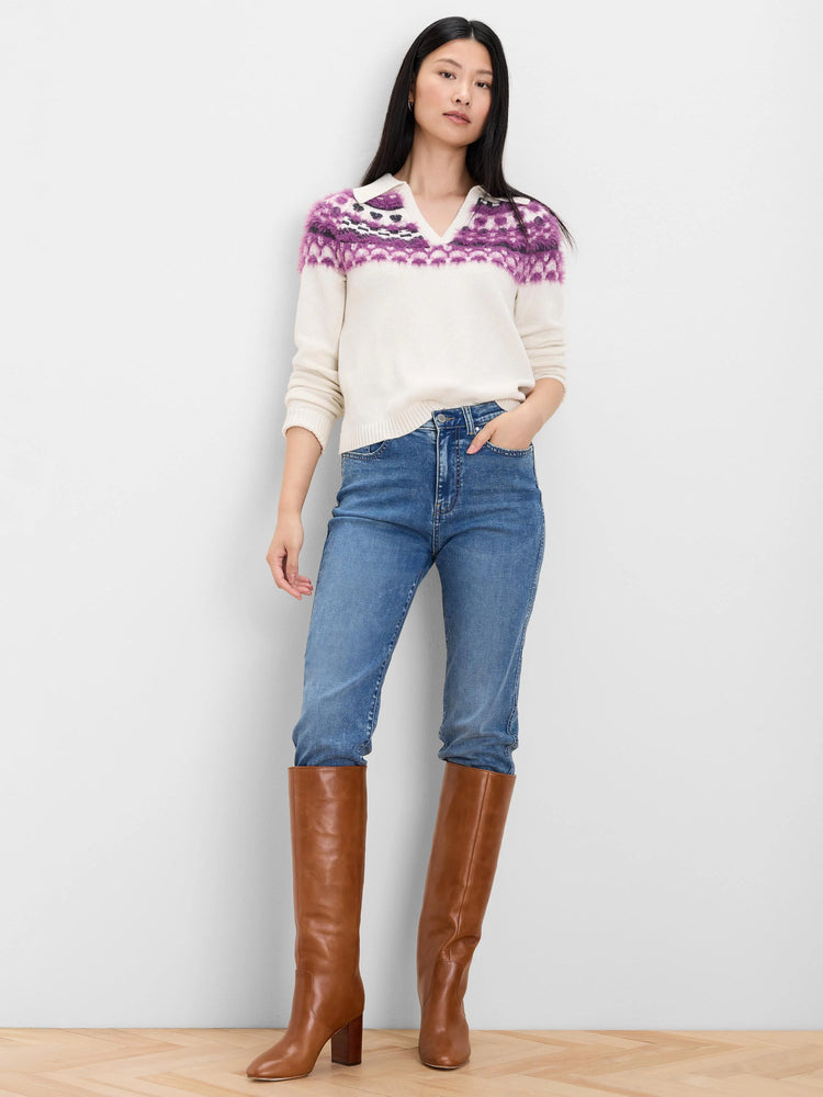 Cream fairisle polo sweater with purple and black pattern across chest and shoulders, with a white collar.
