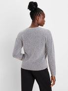 Light grey, fuzzy knit slouchy sweater, back view. Features ribbed cuffs and hem.
