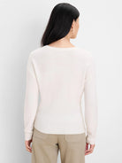 Back view of a cream slouchy scoop sweater with a soft, fuzzy knit texture, ribbed cuffs, and hem.