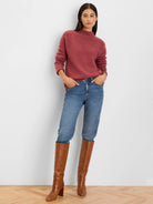 Rose pink, high-neck sweater with long sleeves and a plush, textured knit.