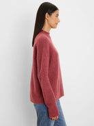 Dusty rose fuzzy mock neck sweater with a relaxed fit, worn by a model in profile.