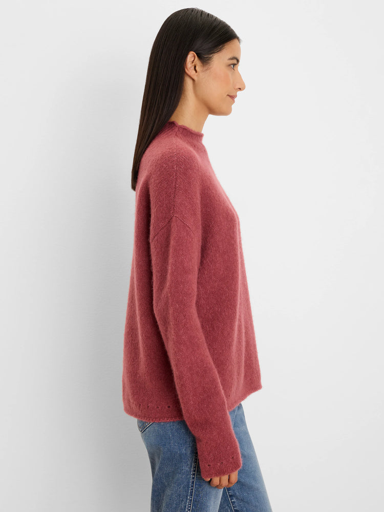 Dusty rose fuzzy mock neck sweater with a relaxed fit, worn by a model in profile.