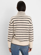 Cream brushed sweater with dark gray horizontal stripes, fuzzy texture, and mock neck.