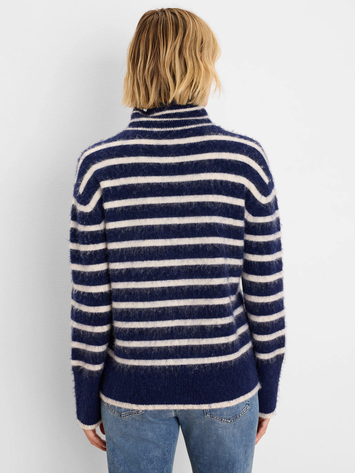 Navy and cream brushed sweater with horizontal stripes and a high neck, seen from the back on a model.