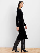Black velvet midi dress with long sleeves, with a gathered detail at the waist.