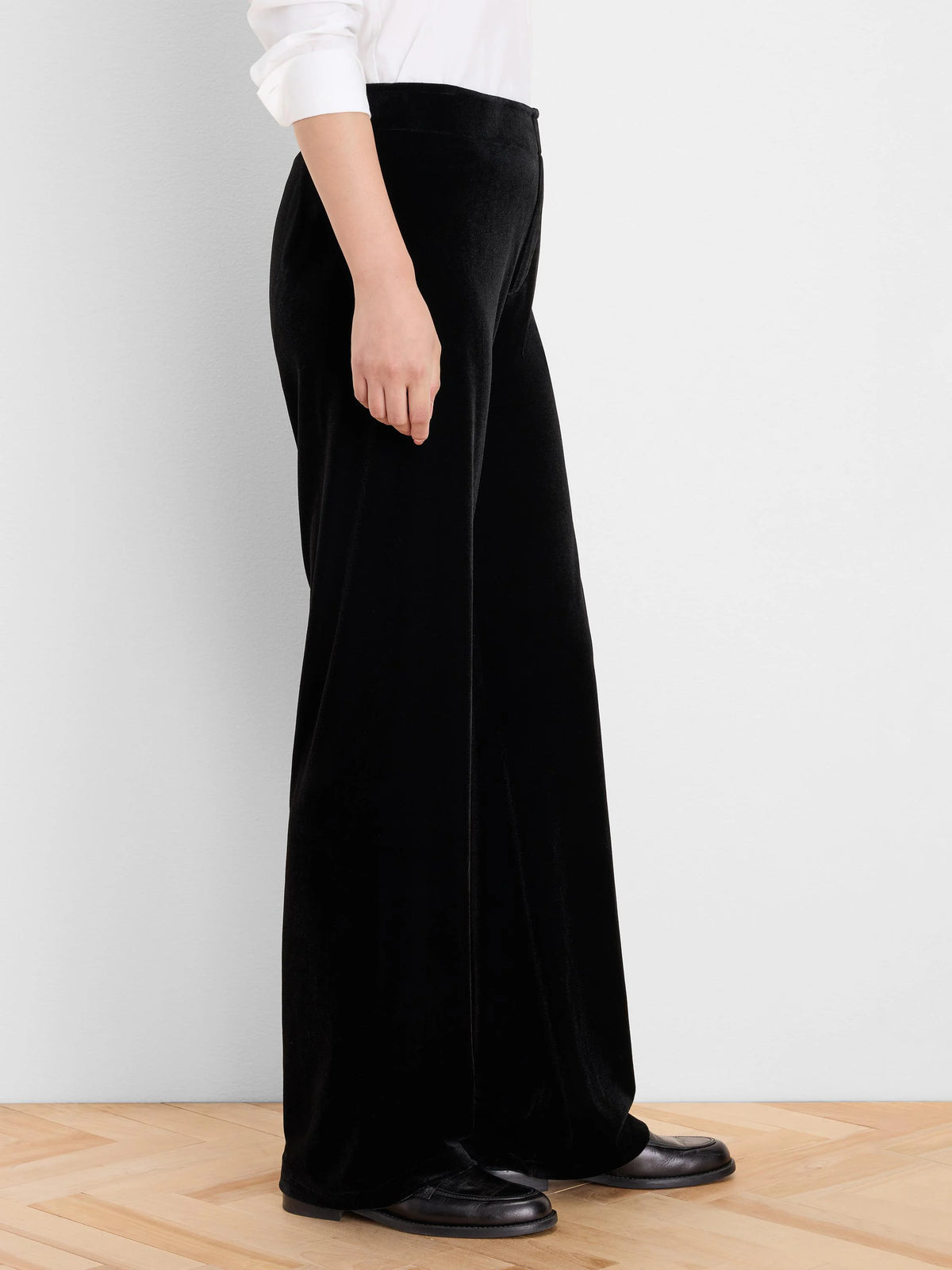 Black velvet wide-leg pants with a soft texture and loose fit, shown on a model from waist to floor.