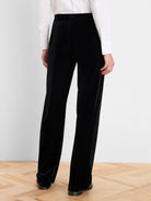 Black velvet wide-leg pants featuring a high waist and smooth, flowing fabric.