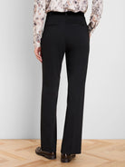 Black pinstripe bootcut pants, seen from the back. Features subtle thin stripes and two horizontal back pockets.