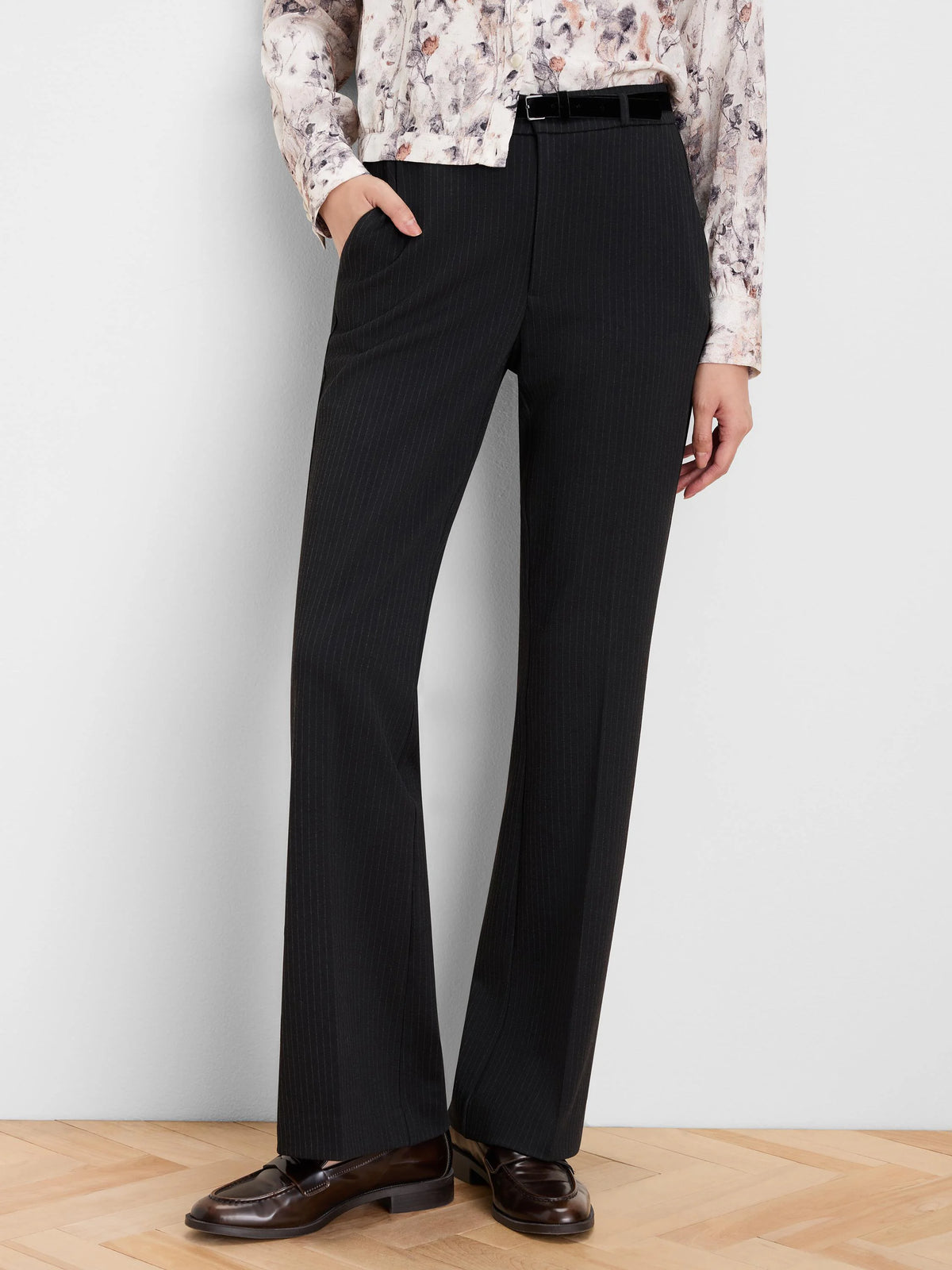 Black bootcut pinstripe pants, high-waisted, with subtle light vertical stripes and a gentle flare at the hem.