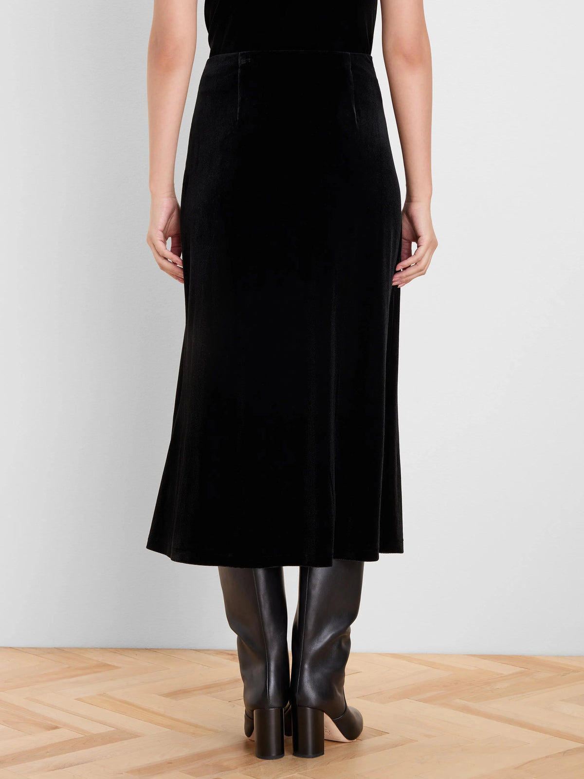 Black velvet midi slip skirt, back view. Smooth, flowing fabric with a subtle sheen.