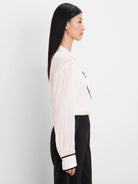 Textured cream shirt with black velvet trim on the collar, button placket, and cuffs.
