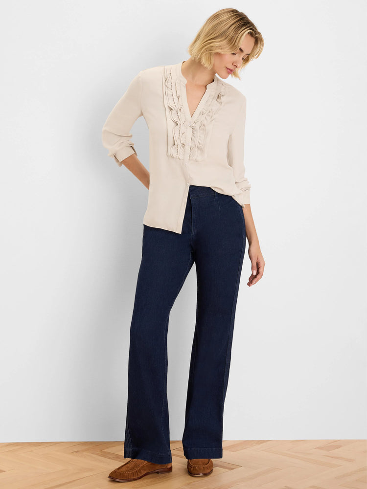Cream ruffle shirt featuring a V-neckline and vertical ruffles framing the front button placket.