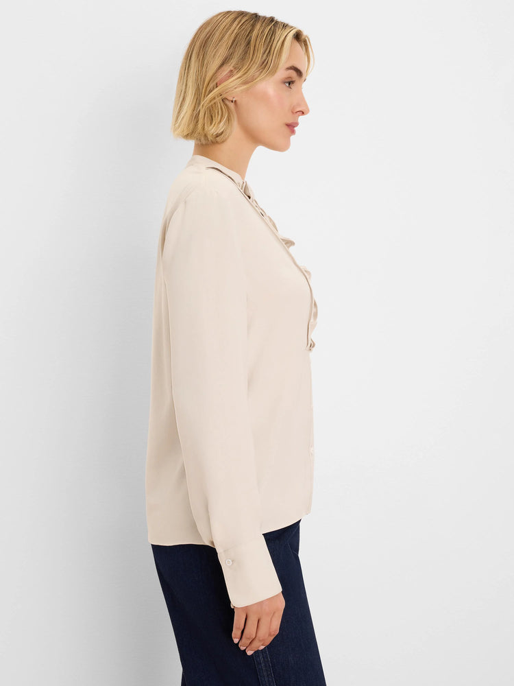 Beige long-sleeve shirt with a ruffled front placket and buttoned cuffs.