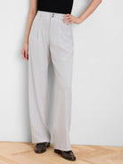 Light grey wide-leg crepe trousers with a high waist, front pleats, and double button closure.