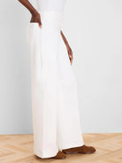 White wide leg jeans on a model. Full length, with visible side pockets and waist belt loops.