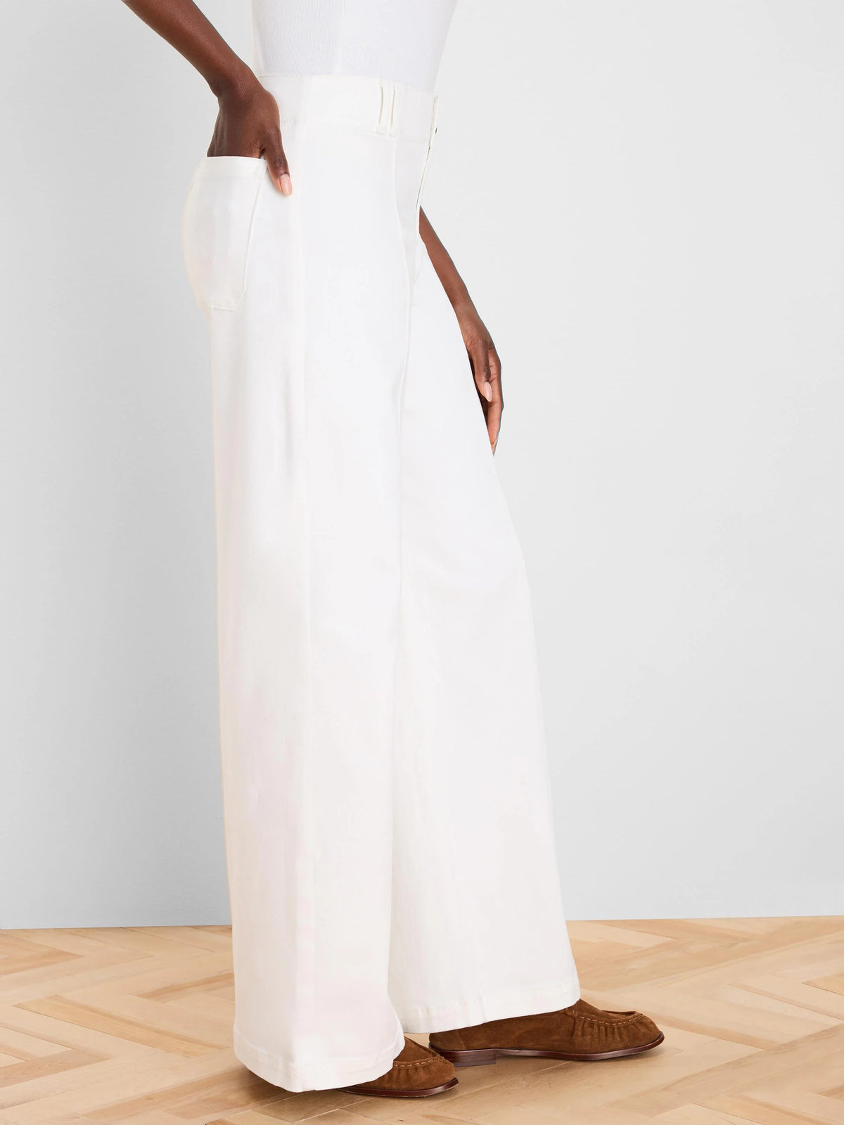 White wide leg jeans on a model. Full length, with visible side pockets and waist belt loops.