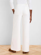 Off-white wide leg jeans, back view on model, showing flat patch pockets, belt loops, and full-length cut.