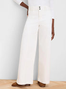 Cream wide-leg jeans with a high waist, two black buttons, and distinct vertical front seams.
