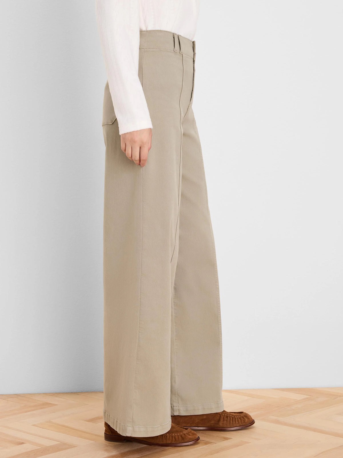 Light taupe, high-waisted, wide-leg jeans, full-length. Worn with a cream long-sleeve top.