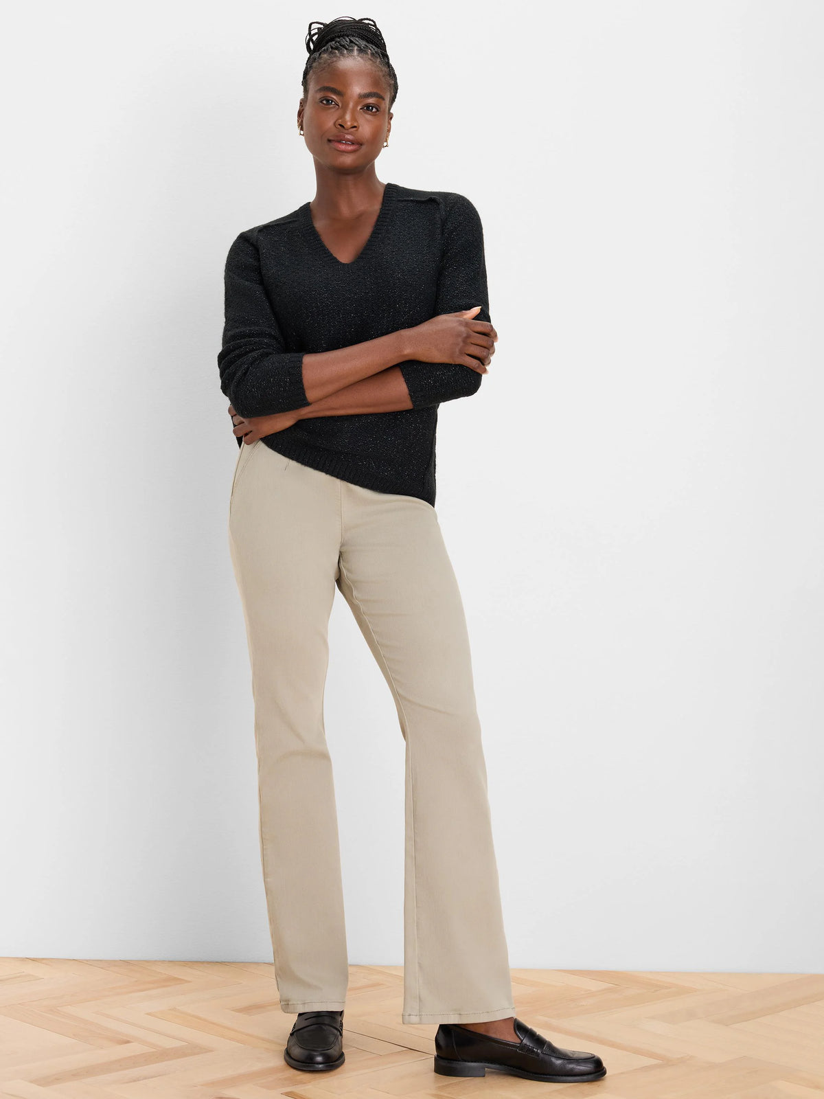 Light beige bootcut jeans on a model, subtly flared from the knee to a wide ankle opening.